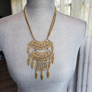 Multi-tiered gold tone necklace.